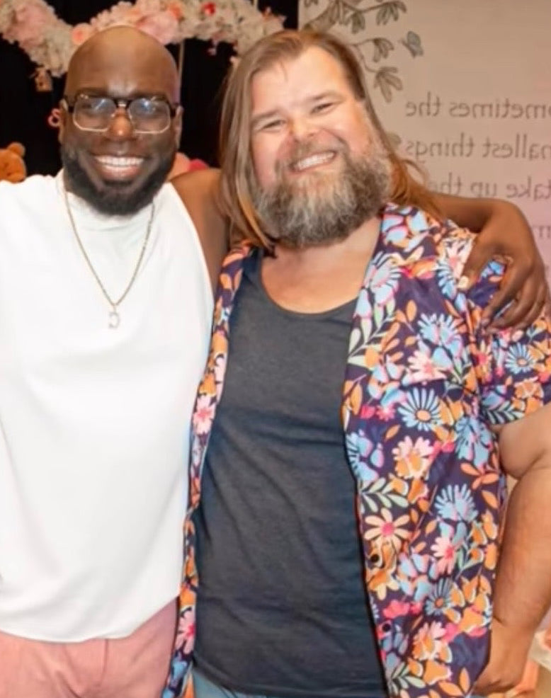 Three men posing together with a decorative arch in the background