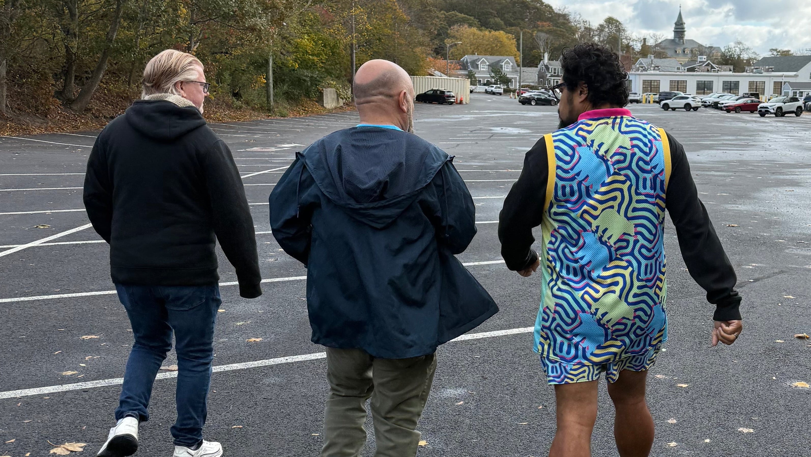 people walking on a road with a tall structure in the background