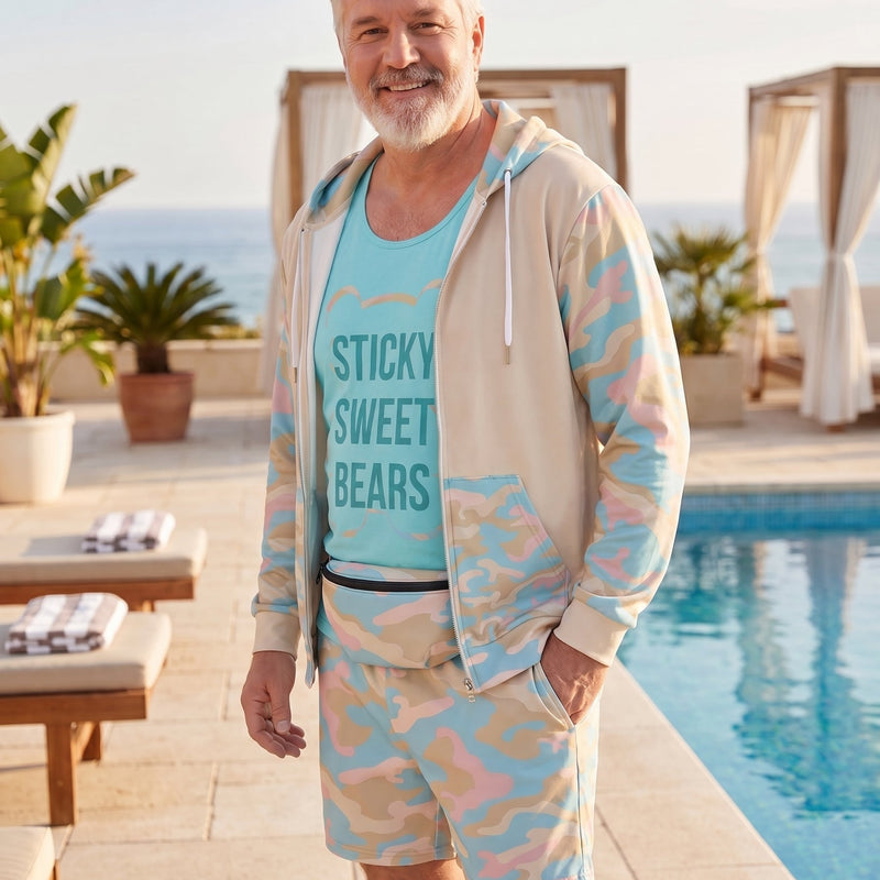 Man wearing a light blue hoodie with text and matching shorts by a poolside.